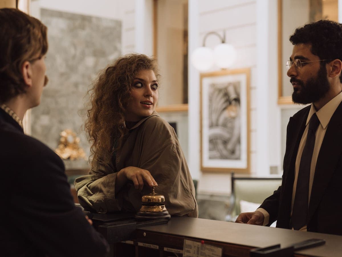 Hóspedes sendo atendidos na recepção de um hotel